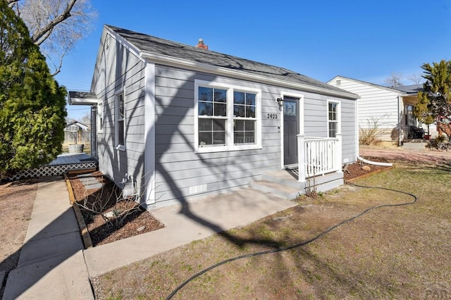 view of front of home featuring roof with shingles and a chimney