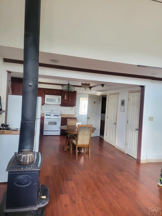 597 Piute Rd, Westcliffe, CO 81252 - dining area featuring a wood stove, dark wood-type flooring, and baseboards