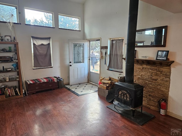 597 Piute Rd, Westcliffe, CO 81252 - entryway with a wood stove, wood finished floors, a towering ceiling, and baseboards