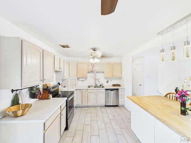 3210 Shalimar Ter, Pueblo, CO 81008 - kitchen with stainless steel appliances, ceiling fan, light countertops, light brown cabinetry, and pendant lighting