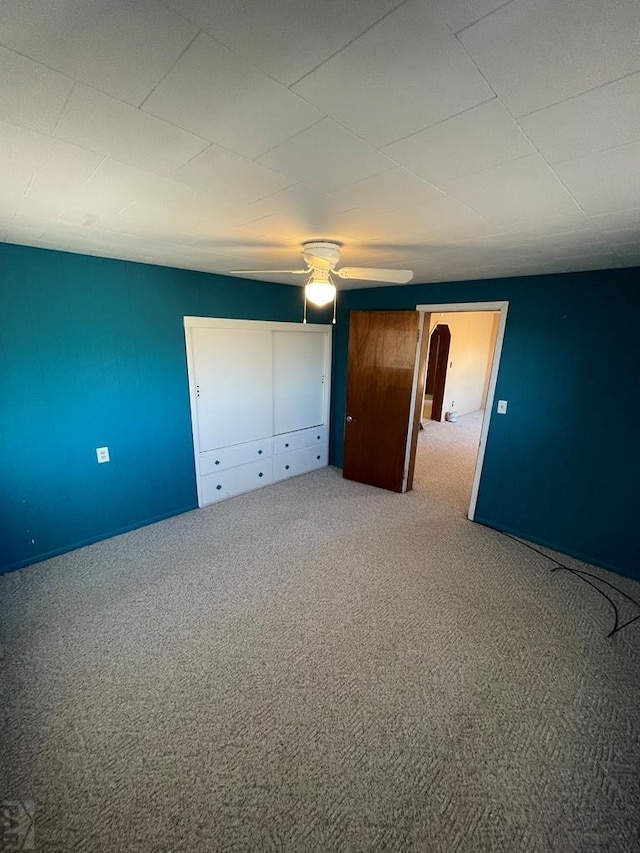 unfurnished bedroom with arched walkways, ceiling fan, and carpet