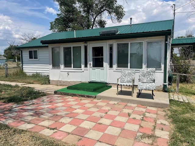 back of property featuring a patio area and metal roof