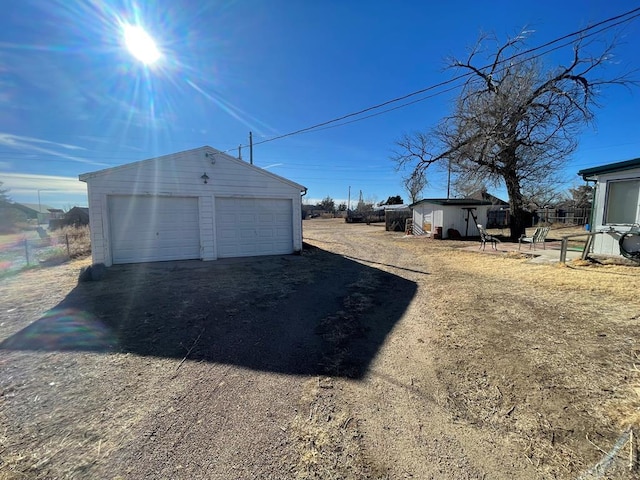 detached garage featuring fence