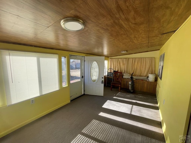 interior space featuring wooden ceiling, dark carpet, and baseboards