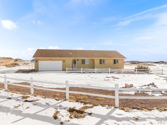 view of front facade with a garage, concrete driveway, fence, and stucco siding