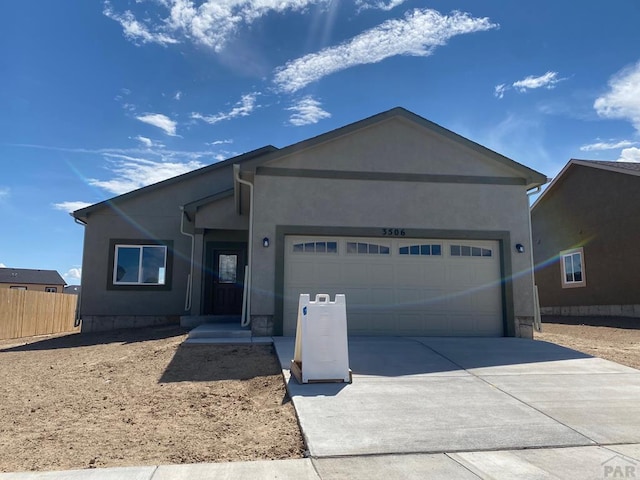 ranch-style home featuring driveway, a garage, fence, and stucco siding