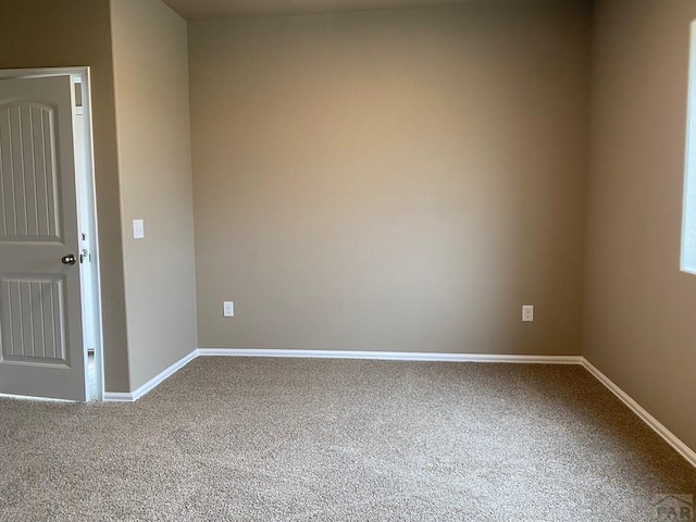 carpeted spare room with baseboards