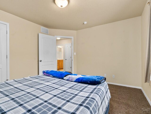 bedroom with dark colored carpet, visible vents, and baseboards