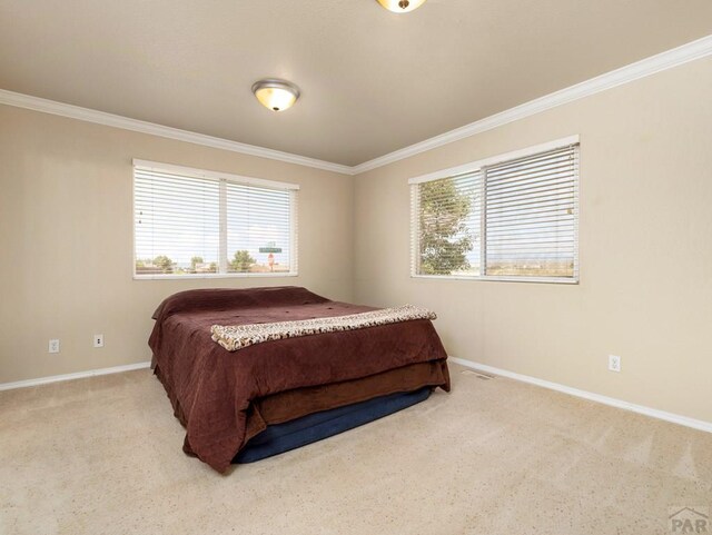 bedroom featuring light carpet, ornamental molding, and multiple windows