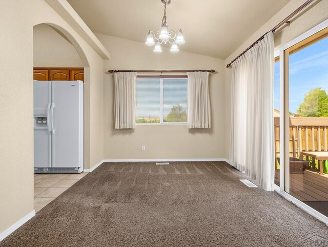 unfurnished dining area with arched walkways, light carpet, vaulted ceiling, and a notable chandelier