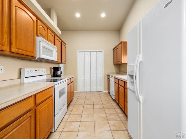 kitchen featuring brown cabinets, light tile patterned floors, recessed lighting, light countertops, and white appliances