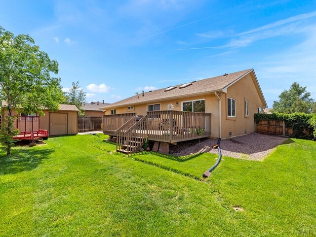 rear view of property with an outbuilding, a deck, a fenced backyard, a storage shed, and stucco siding