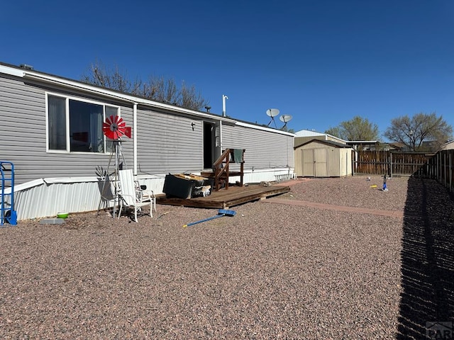 2795 Elizabeth St Unit 39, Canon City, CO 81212 - rear view of property featuring a shed, a fenced backyard, a deck, and an outdoor structure