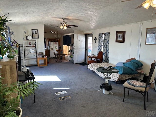 2795 Elizabeth St Unit 39, Canon City, CO 81212 - carpeted living area featuring a textured ceiling, visible vents, a ceiling fan, and vaulted ceiling