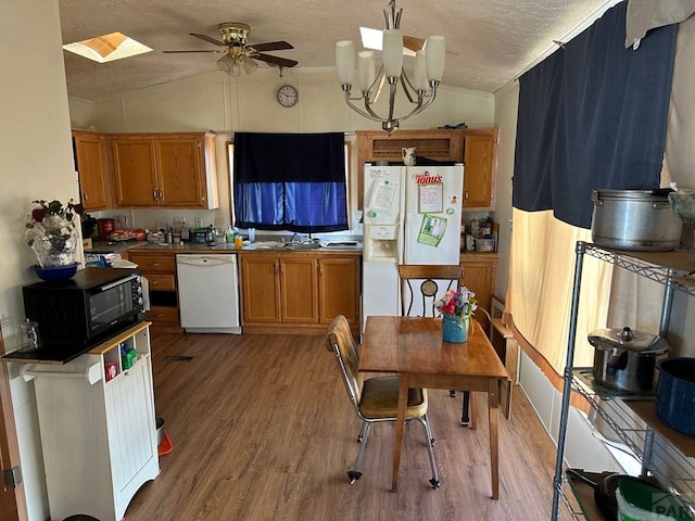 2795 Elizabeth St Unit 39, Canon City, CO 81212 - kitchen featuring white appliances, a textured ceiling, brown cabinets, light wood finished floors, and lofted ceiling
