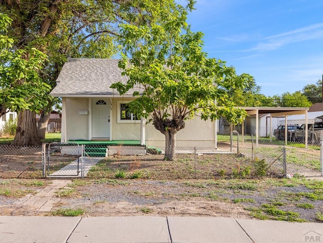 view of front of property with a fenced front yard, a gate, a shingled roof, and stucco siding