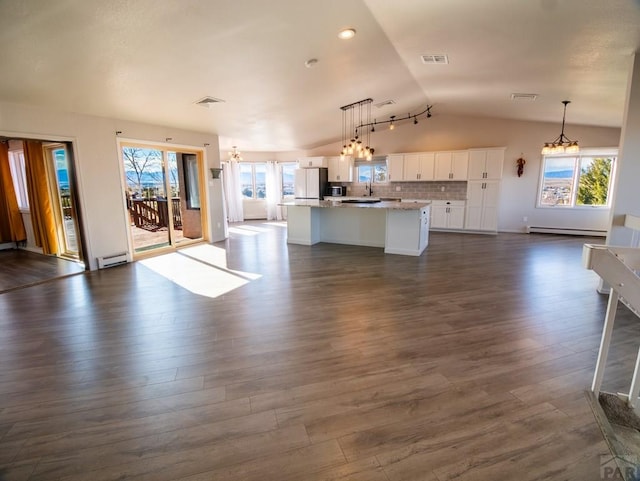 kitchen with open floor plan, baseboard heating, and freestanding refrigerator