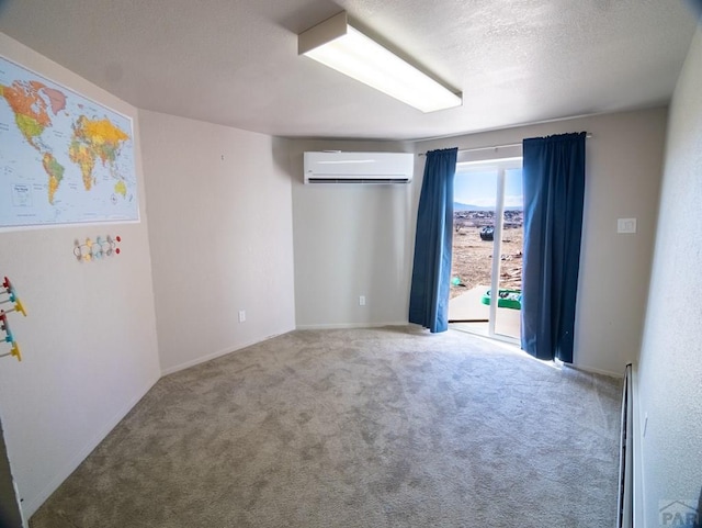 carpeted empty room featuring a baseboard heating unit, a textured ceiling, and a wall mounted air conditioner