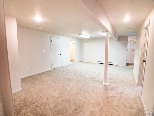 finished basement with light carpet, a baseboard radiator, and baseboards