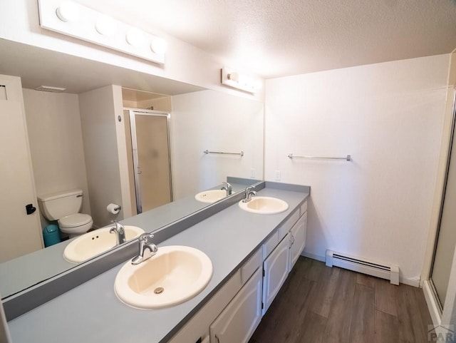 full bath with a stall shower, a baseboard radiator, a sink, and wood finished floors