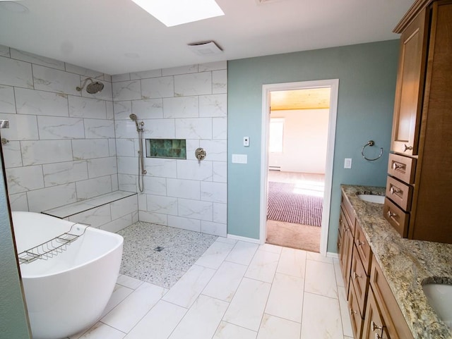 bathroom featuring double vanity, a skylight, tiled shower, a freestanding tub, and a sink