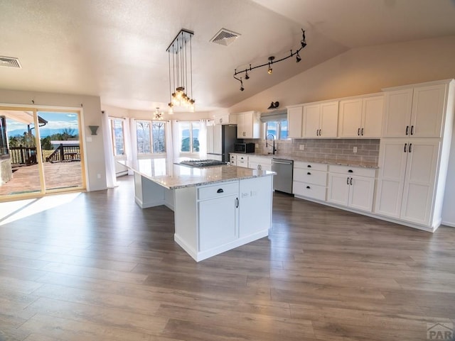 kitchen featuring visible vents, appliances with stainless steel finishes, white cabinets, vaulted ceiling, and a kitchen island