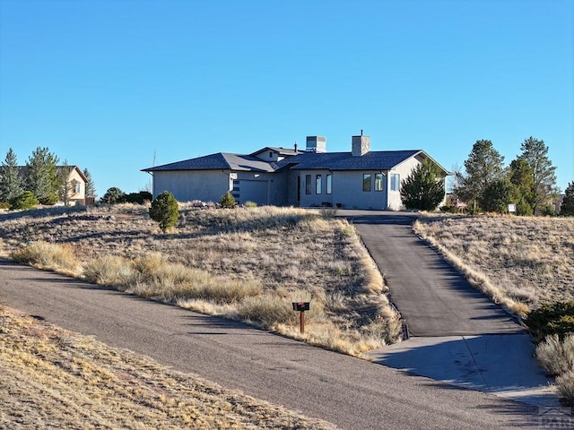 view of front of property with concrete driveway and a chimney