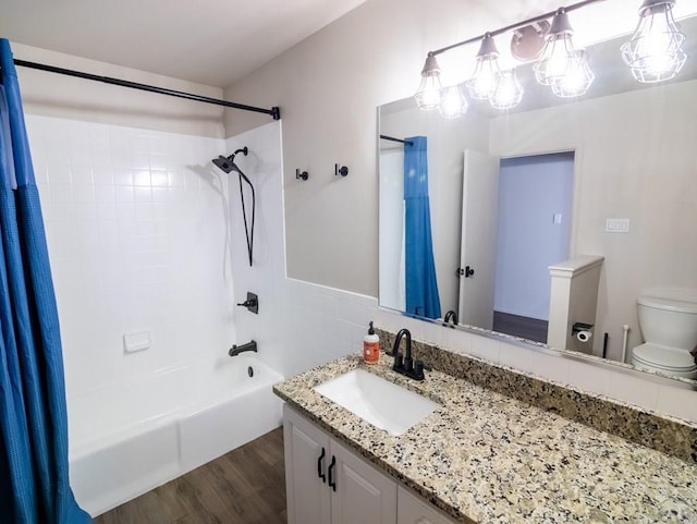 bathroom with toilet, shower / tub combo, wood finished floors, and vanity