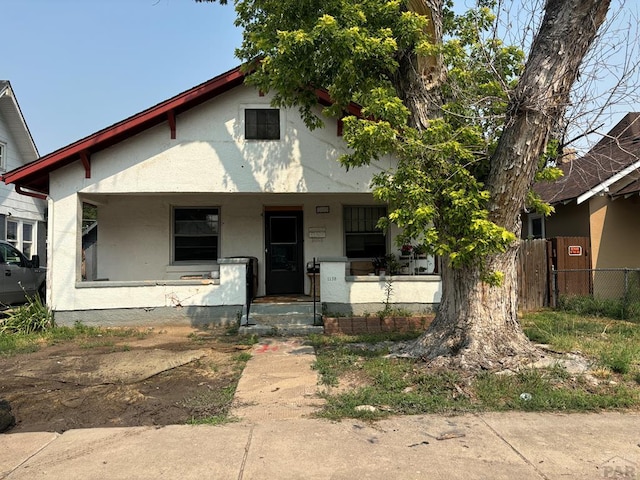 view of front facade featuring covered porch and fence