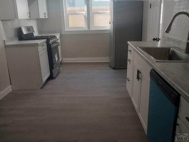 1025 W 17th St, Pueblo, CO 81003 - kitchen featuring stainless steel appliances, a sink, baseboards, and light wood-type flooring