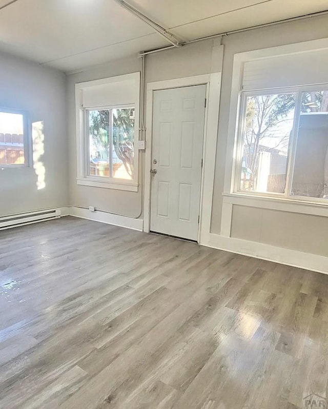 1025 W 17th St, Pueblo, CO 81003 - foyer featuring a baseboard heating unit, wood finished floors, and plenty of natural light