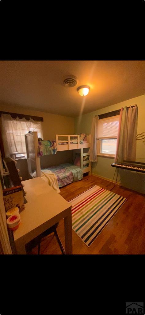 bedroom featuring wood finished floors and visible vents