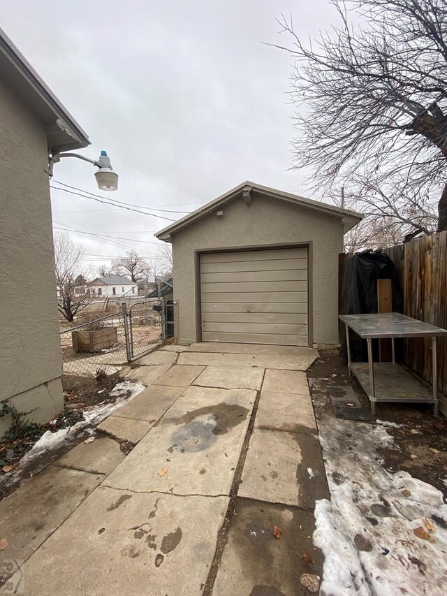 garage featuring fence and driveway