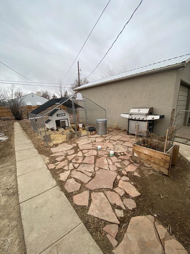 view of side of property featuring metal roof and stucco siding