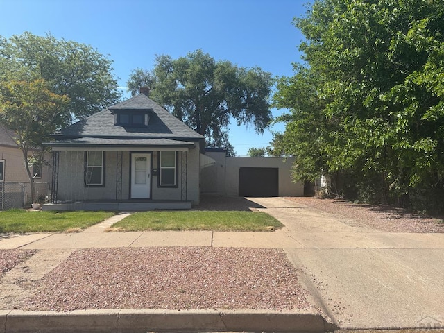 1610 E 6th St, Pueblo, CO 81001 - view of front facade featuring concrete driveway, a garage, covered porch, and a shingled roof