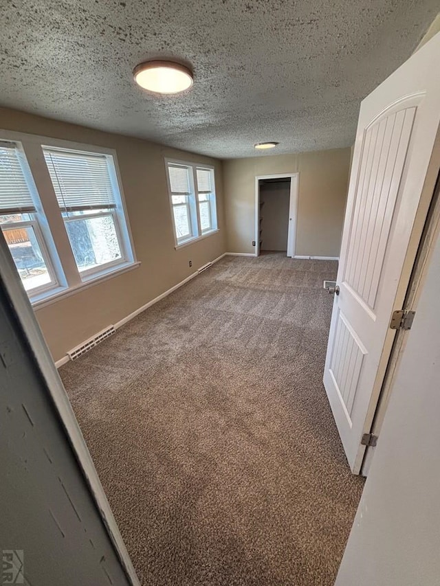 1610 E 6th St, Pueblo, CO 81001 - spare room featuring a textured ceiling, baseboards, and carpet floors