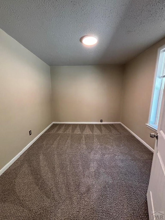 1610 E 6th St, Pueblo, CO 81001 - empty room with dark carpet, a textured ceiling, and baseboards