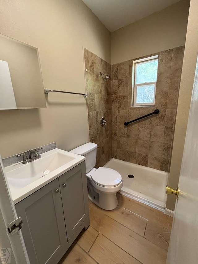 1610 E 6th St, Pueblo, CO 81001 - full bath with vanity, a tile shower, toilet, and wood finished floors