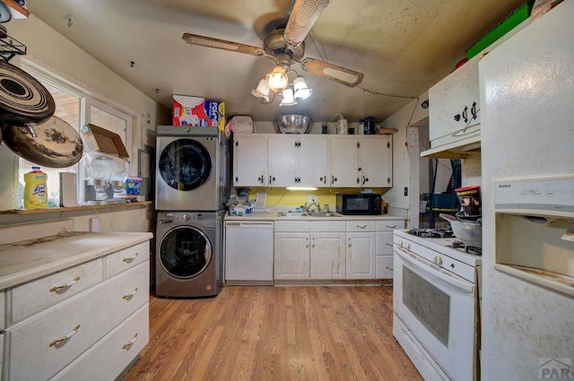 2101 Salt Dr, Colorado Springs, CO 80910 - kitchen with white appliances, stacked washer and clothes dryer, white cabinets, light wood finished floors, and a ceiling fan