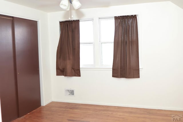 unfurnished bedroom with light wood-style flooring, a closet, visible vents, and baseboards