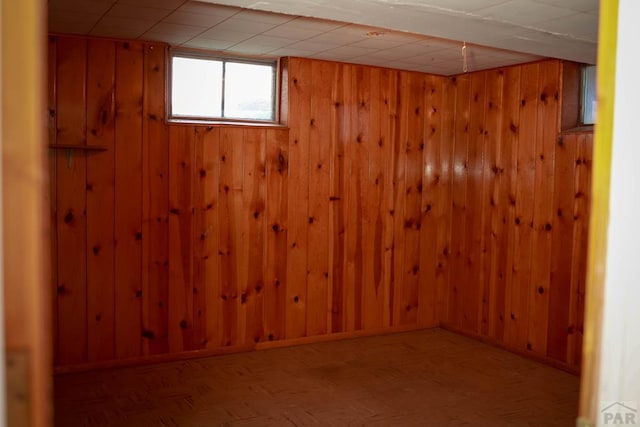 below grade area featuring wood walls and baseboards