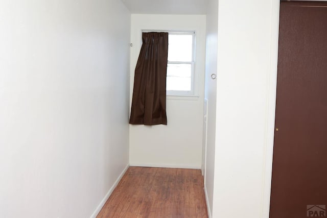 corridor featuring wood finished floors and baseboards