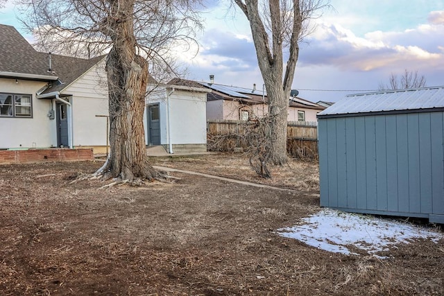 view of yard with a storage shed, fence, and an outdoor structure