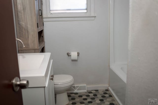 bathroom with toilet, vanity, visible vents, baseboards, and walk in shower