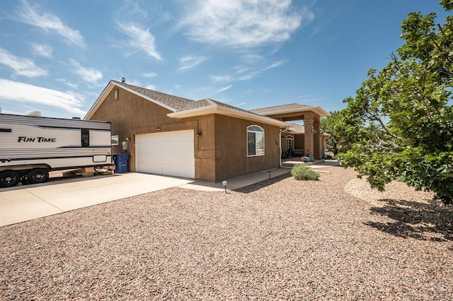 view of front of home featuring driveway, a garage, and stucco siding