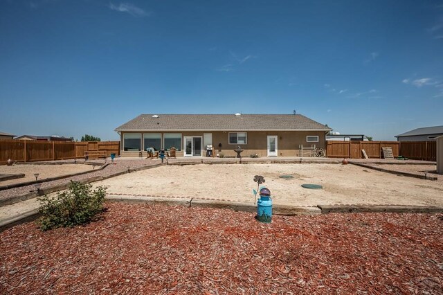 rear view of house with a fenced backyard and stucco siding