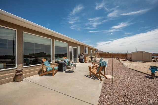 view of patio featuring a storage shed, an outbuilding, and a fenced backyard