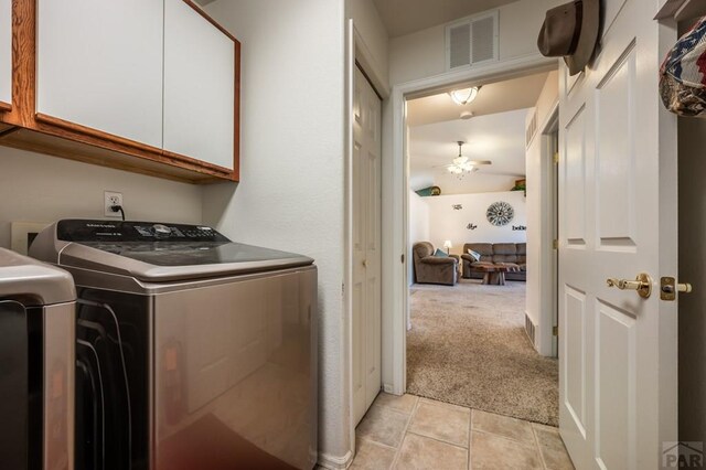 washroom featuring light carpet, cabinet space, visible vents, washer and clothes dryer, and light tile patterned flooring