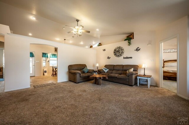 carpeted living room featuring lofted ceiling, ceiling fan, arched walkways, and recessed lighting