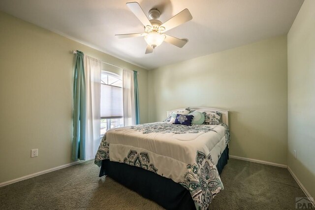 bedroom with dark carpet, baseboards, and ceiling fan